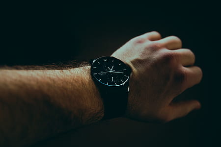 person wearing black analog watch with strap thumbnail