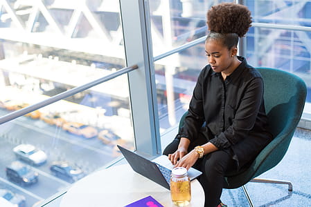 Woman in Black Button-up Top Sitting on Chair thumbnail