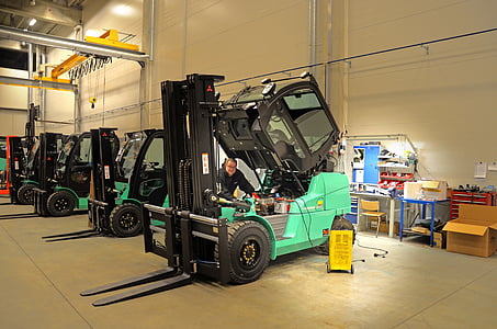 teal-and-black forklifts on beige building thumbnail