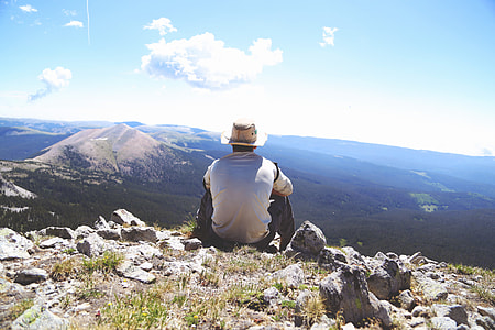 man in white top sitting on rocks thumbnail