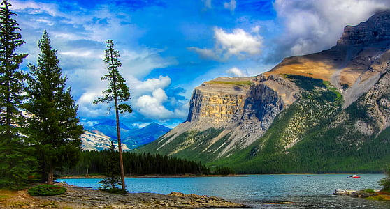 body of water surrounded by trees near mountain range thumbnail