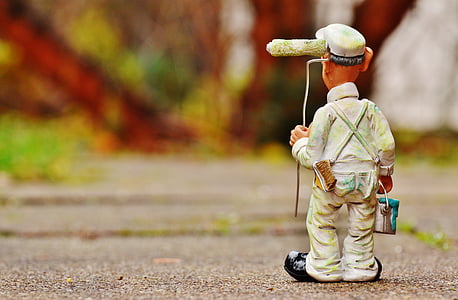 closeup photoghraphy of man holding paint can and paint roller on concrete road thumbnail