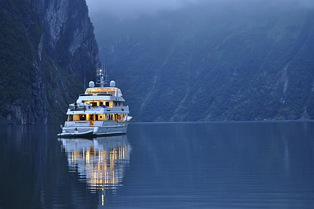 white yacht beside hill thumbnail