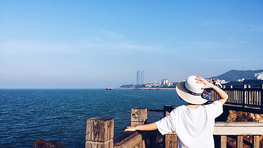 person holding hat standing near fence thumbnail