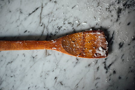 brown wooden spatula on white granite pavement thumbnail