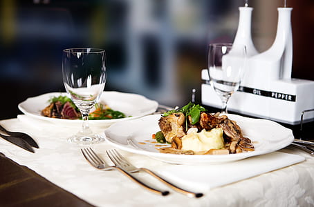 cooked food on plates beside drinking glasses thumbnail