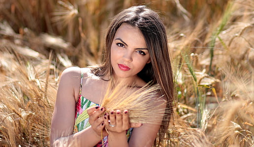 selective focus photography of woman holding hay thumbnail