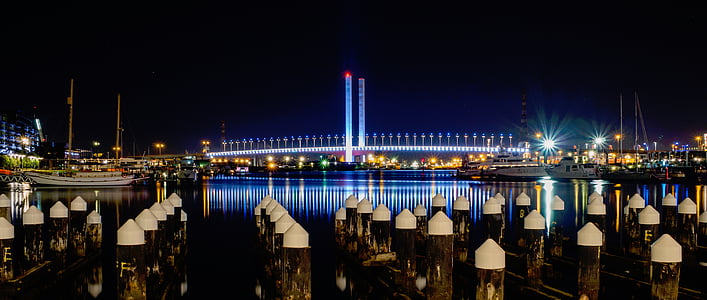 lighted bridge near high buildings at nighttime thumbnail