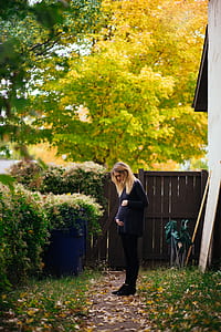 woman standing beside green trees thumbnail