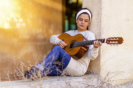 woman playing brown classical guitar thumbnail