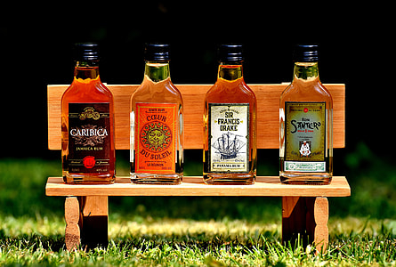 four beverage bottles on wooden bench thumbnail