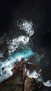 aerial photography of water flowing beside rocks thumbnail