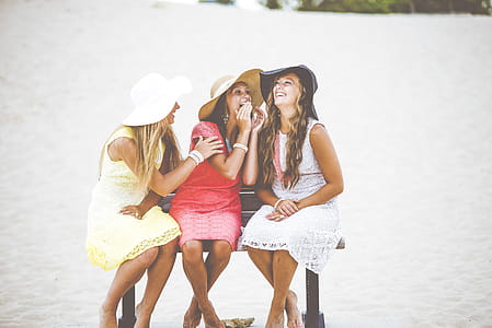 , three women sitting on black bench thumbnail
