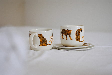 two white ceramic teacups with saucers thumbnail