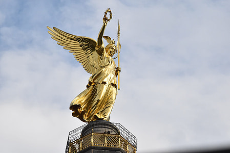 gold-colored angel holding staff statue at daytime thumbnail