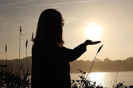 silhouette of a woman looking at the body of water thumbnail