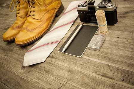 pair of brown leather Derby shoes beside white and red striped necktie thumbnail