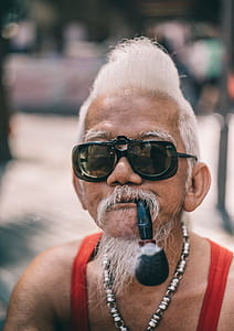 man wearing sunglasses and smoking on pipe thumbnail