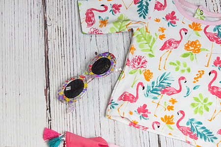 purple sunglasses with white and pink shirt on white table thumbnail