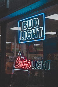 Bud Light and Coors Light neon light signages on clear glass wall thumbnail