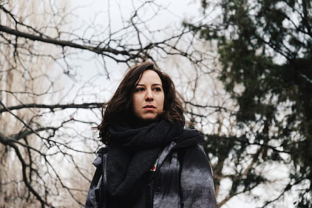 woman looking to her left with trees background thumbnail