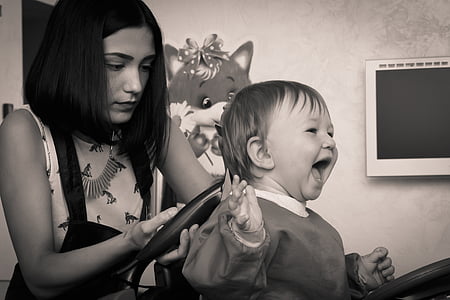 grayscale photography of girl doing hair cut on child thumbnail