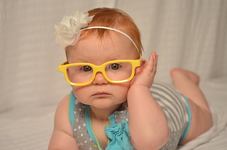 baby in gray and blue dress lying on crib thumbnail