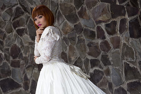 woman standing near wall wearing wedding dress thumbnail