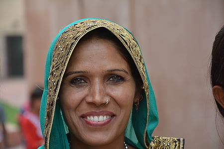smiling woman wearing teal and brown floral cape thumbnail