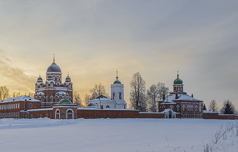 brown building surrounded by snow at day thumbnail