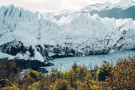 snow capped mountains beside body of water thumbnail