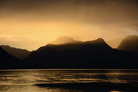 sepia photography of body of water near mountain thumbnail