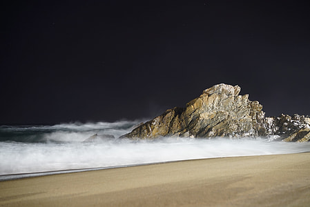 grey rock on seashore during nighttime thumbnail