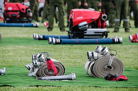 two grey fire hoses on green grass field thumbnail