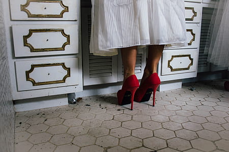 person in white skirt wearing pair of red stilettos thumbnail