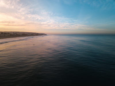 body of water near gray shore during daytime thumbnail