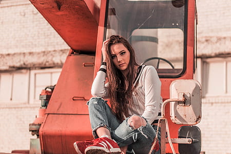 woman sitting on red heavy equipment during adytime thumbnail