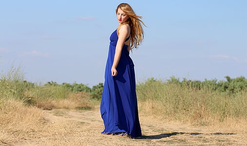 woman standing near green grass field during daytime thumbnail