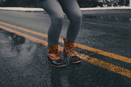 woman in duck boots jumping over water thumbnail