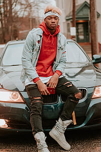 man sitting on BMW hood during daytime thumbnail
