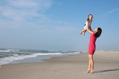 woman raising child near seashore thumbnail