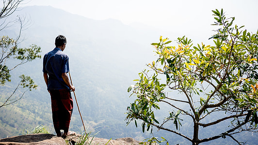 man in blue shirt standing on cliff thumbnail