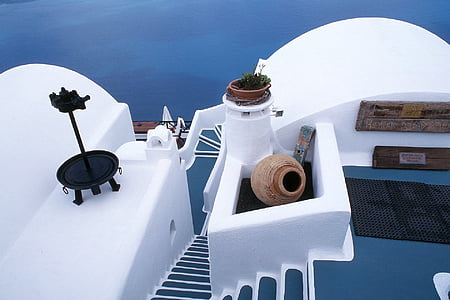 brown jar and white metal stand on white wall near stairs thumbnail
