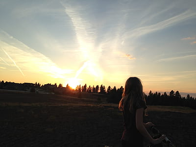 woman looking at sunrise on her bicycle thumbnail