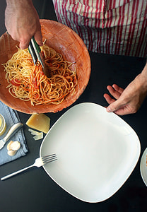 person using tongs holding spaghetti thumbnail