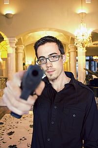 man wearing black dress shirt pointing gun forward thumbnail