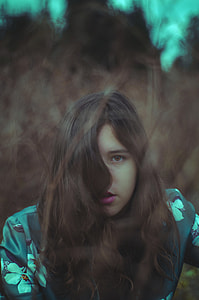low light photography of woman in blue and white floral top thumbnail