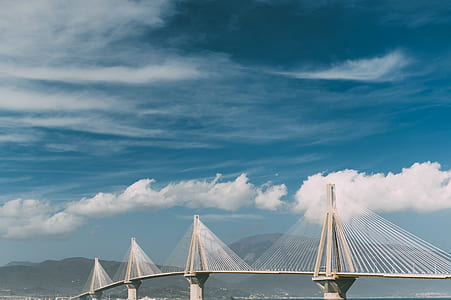 white suspension bridge near mountains thumbnail