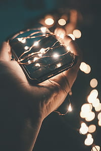 Person Holding Space Gray Iphone 6 With String Lights during Nighttime thumbnail