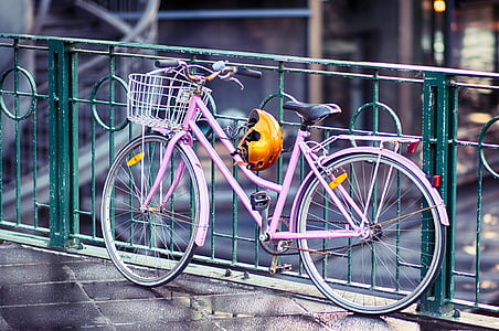 pink rigid bicycle beside green metal railings thumbnail